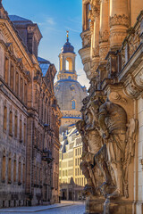 Cityscape - street view with sculptures of gatekeepers on the George Gate of Dresden Castle against...