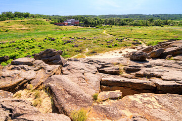 Summer landscape - view of the ancient mound of sandstone boulders and the building of the museum with the surrounding area, the archeological preserve Kamyana Mohyla, Ukraine