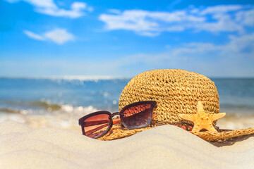 Close-up view of a sun hat on a sandy beach by the sea, selective focus. Beach holiday concept,...