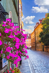 Summer cityscape - view of flowers on narrow streets with old houses in the Old Town of Warsaw, Poland