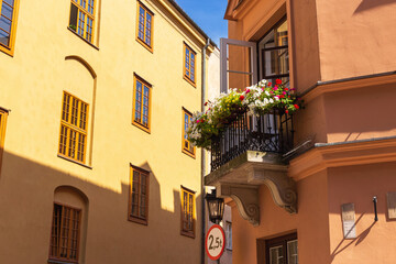 Summer cityscape - view of old houses with flowers on the balconies on narrow streets in the Old Town of Warsaw, Poland