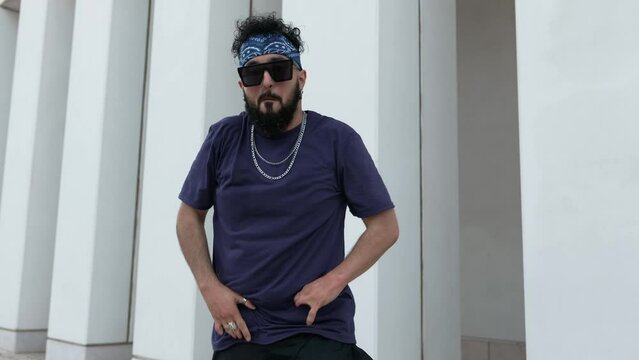 A talented male dancer in streetwear flaunts his moves outdoors against an urban backdrop, exuding energy and style