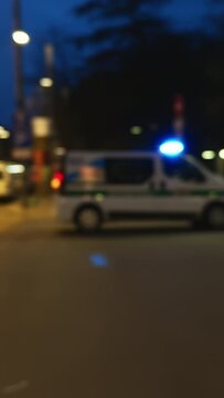 a blurry picture of a city street at night with a police car in the foreground