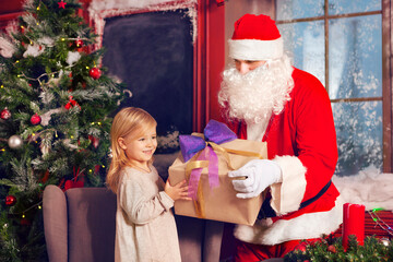 Smiling little girl with Santa Claus and gifts