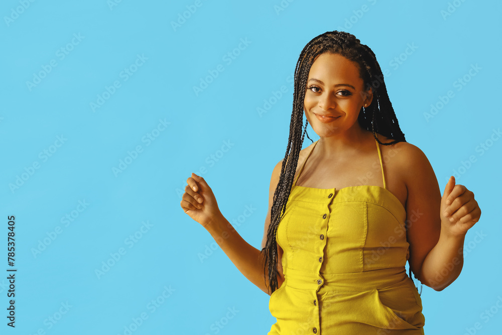 Wall mural portrait of young adult beautiful african american woman smiling and dancing with braid hair posing at studio