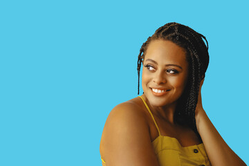 closeup portrait of smiling young beautiful african american woman braid hair posing at studio looking away at copy space