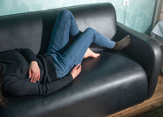 Bare feet of woman lying on sofa.