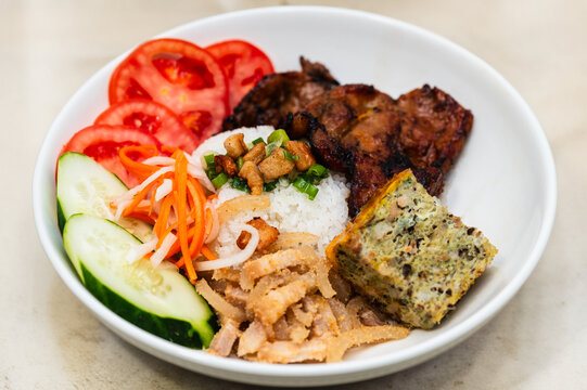 Cơm Tấm. Vietnamese Broken rice with grilled pork, steamed egg, and fresh vegetable