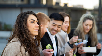 Business people on lunch time outdoors eating home made food. Corporate woman is worried and thoughtful