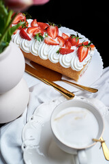 sponge roll with cream, decorated with fresh strawberries