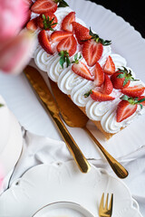 sponge roll with cream, decorated with fresh strawberries