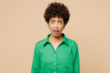 Young sad mad furious outraged offended woman of African American ethnicity wears green shirt...