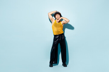 Full body young happy gay Latin man wears mesh tank top hat clothes looking camera posing isolated on plain pastel light blue cyan background studio portrait. Pride day June month love LGBT concept.