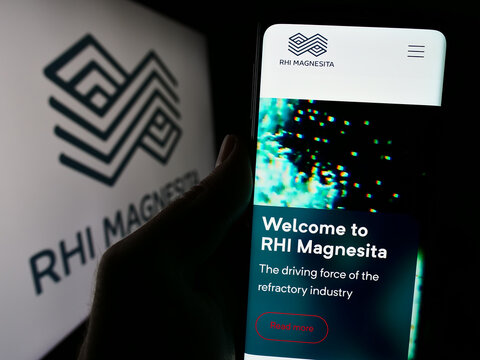 Stuttgart, Germany - 04-07-2024: Person holding cellphone with webpage of refractory products company RHI Magnesita N.V. in front of logo. Focus on center of phone display.