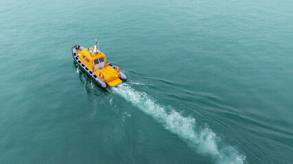 Orange rescue or coast guard patrol boat, patrolling. Police motor boat