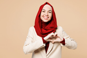 Young Arabian Asian Muslim woman wear red abaya hijab suit clothes showing shape heart with hands...