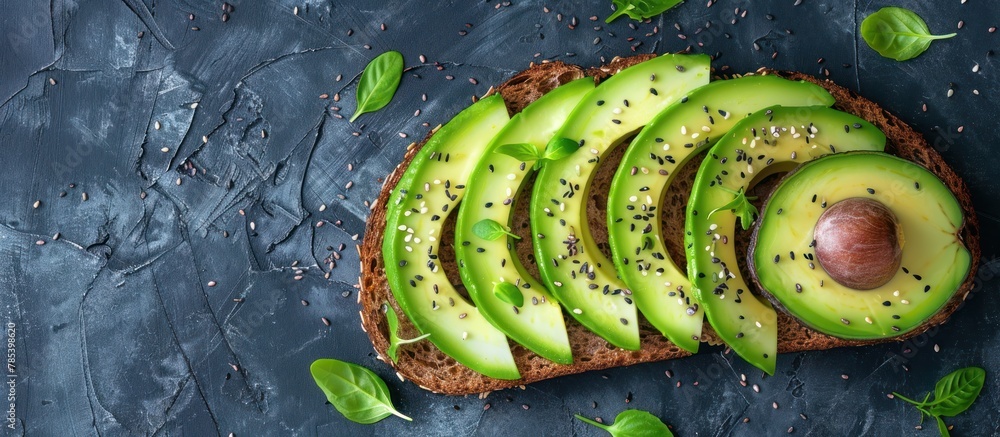 Poster fresh avocado slices neatly arranged on a piece of bread, creating a simple and delicious breakfast 