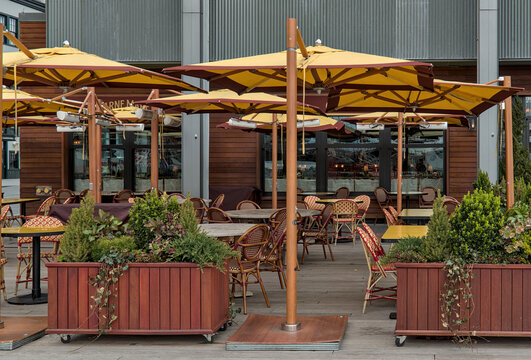 outdoor dining patio with plants and umbrellas to protect from the sun (empty, no people) restaurant outside seating tables chairs shade luxury travel manhattan downtown