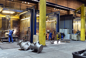 workers in an industrial plant - workplace foundry - production of steel castings - 785400876
