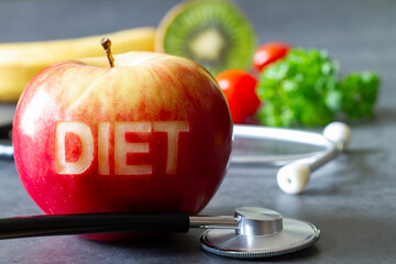 Red apple with cut-out word diet, stethoscope and fruits, diet and healthy lifestyle concept
