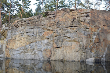 Vertical wall of granite quarry.