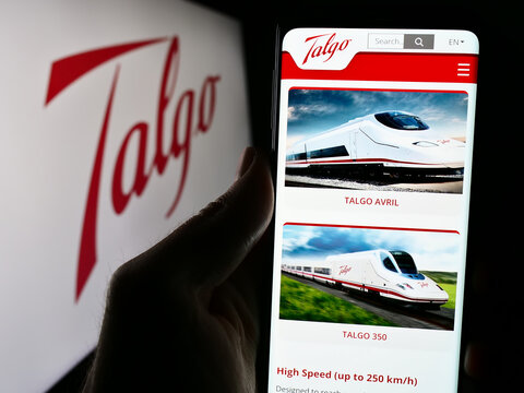 Stuttgart, Germany - 04-08-2024: Person holding cellphone with webpage of Spanish train manufacturing company Talgo S.A. in front of logo. Focus on center of phone display.