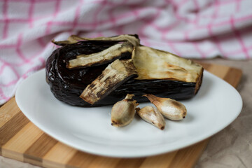 Fried eggplant and garlic on a white plate.