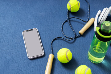 Vertical image of fitness accessories on the blue yoga mat. Empty space