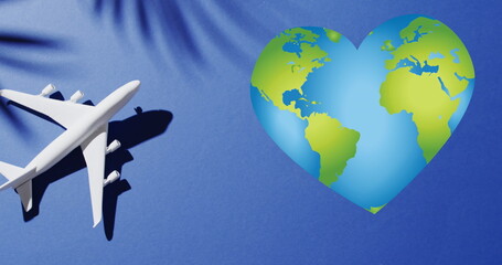 Image of heart of globe over shadow of leaves and plane