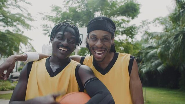 Medium portrait of two African American friends posing for camera during basketball training outdoors