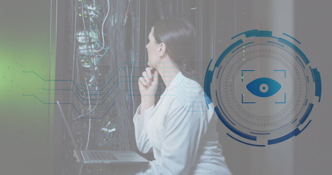 Image of eye retina scanner over caucasian female engineer using laptop working at server room
