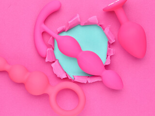 anal plugs and dildo sex toys over pink background - obrazy, fototapety, plakaty