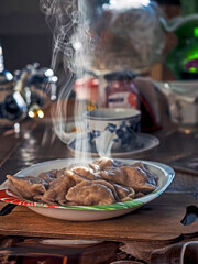 a plate of mouth-watering hot dumplings, steam rises above the plate - 785412667
