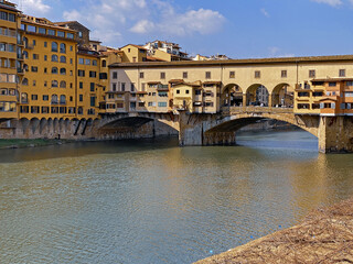 Fototapeta na wymiar View from the Ponte Vecchio over the Arno river, in the ancient medieval city of Florence, Italy.