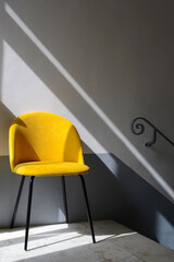 Empty space with yellow chair. Natural sunlight. Play of light and shadow. Fragment of an interior...