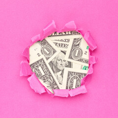 US dollars bills in the hole of pink paper - 785415080