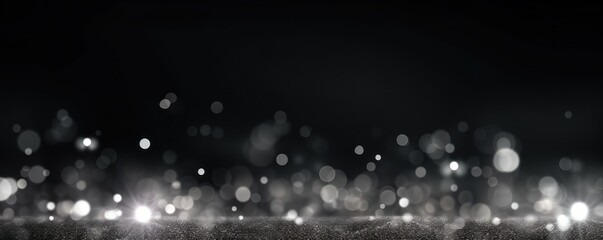 Silver abstract glowing bokeh lights on a black background with space for text or product display. 