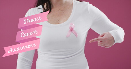 Breast cancer awareness text banner against mid section of woman wearing pink ribbon on her chest