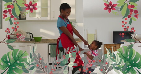 Image of plants and flowers over happy african american mother and daughter dancing in kitchen