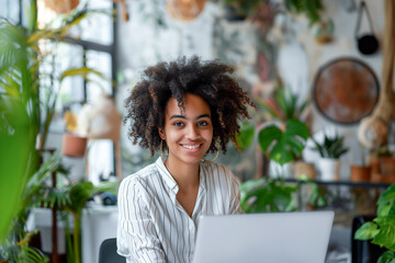 Happy young woman working on a laptop in office