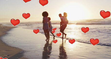 Image of hearts over african american family at beach