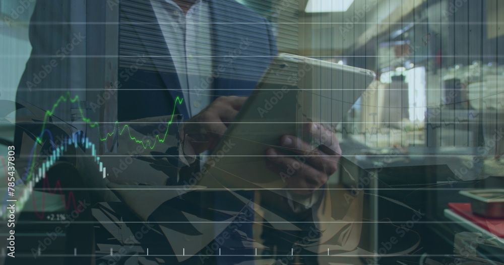 Poster image of financial data and graphs over hands of caucasian businessman using tablet