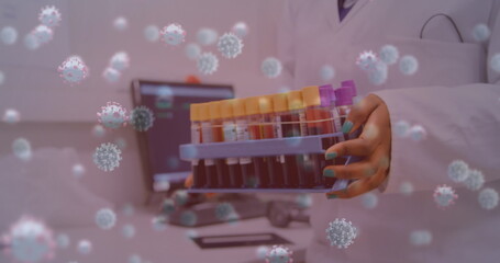 Image of virus cells over biracial female scientist with test tubes