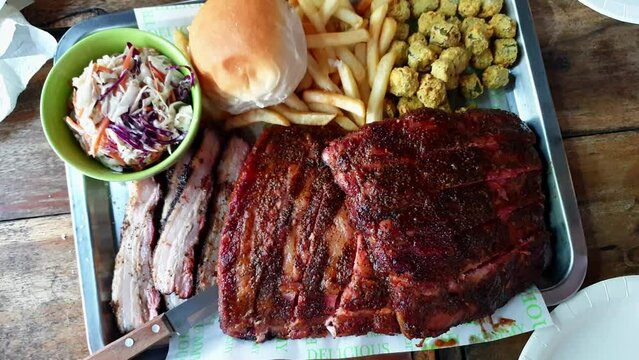 Smoked Texas bbq pork ribs and belly with coleslaw and fries top view