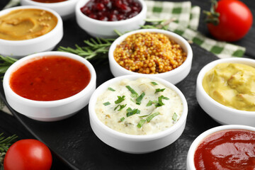 Different tasty sauces in bowls on table, closeup