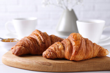 Fresh croissants on white wooden table. Tasty breakfast