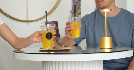 two people drinking orange juice