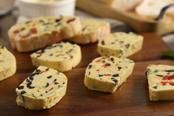 Tasty butter with olives, chili pepper, parsley and bread on table, closeup