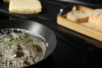 Melting butter in frying pan on cooktop, closeup. Space for text