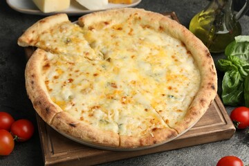 Delicious cheese pizza and ingredients on dark grey table